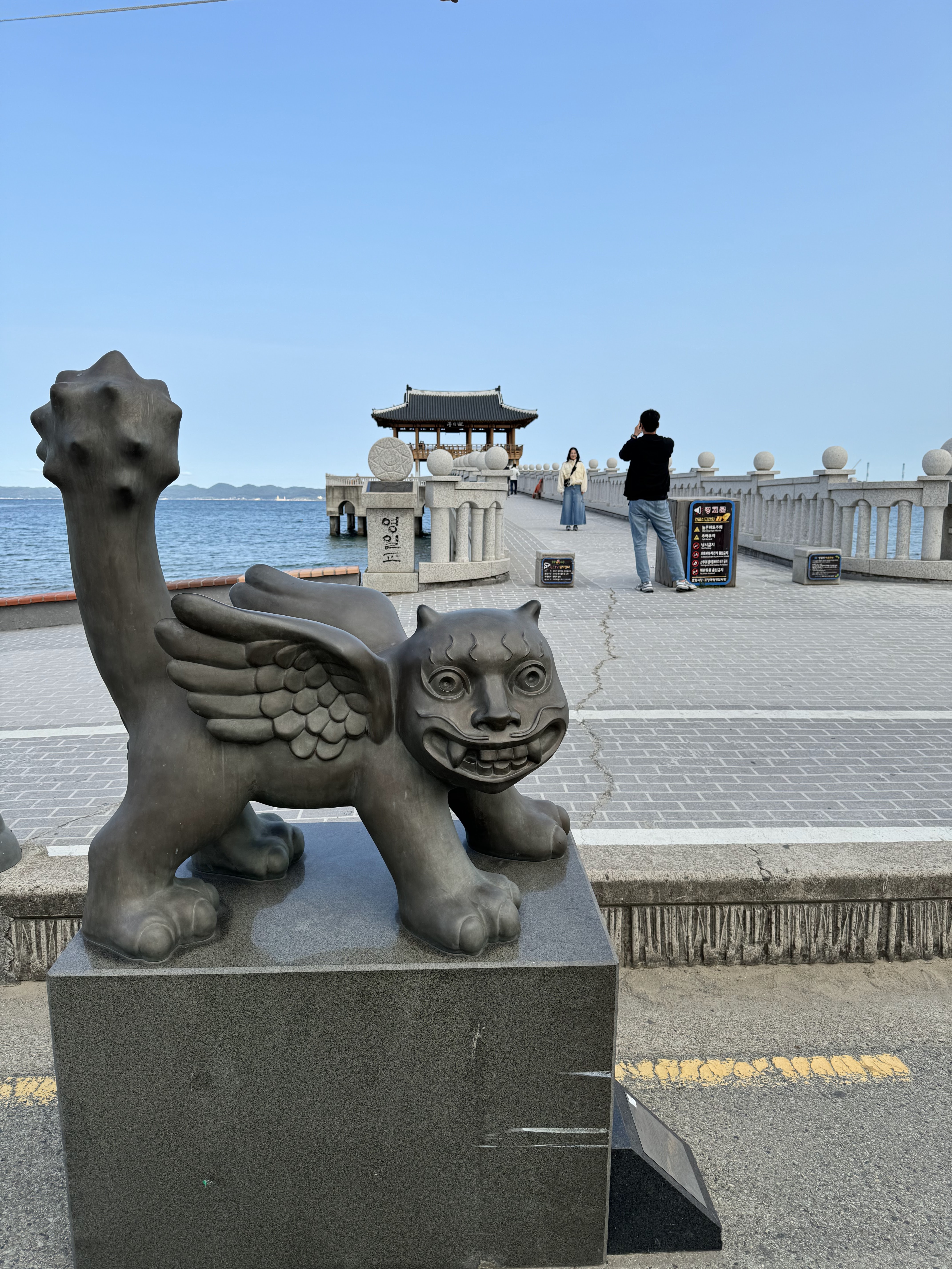 高处全景远眺，将「沙滩—步道—海湾—城市」四层地景收进一帧。